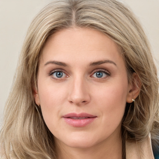 Joyful white young-adult female with long  brown hair and blue eyes