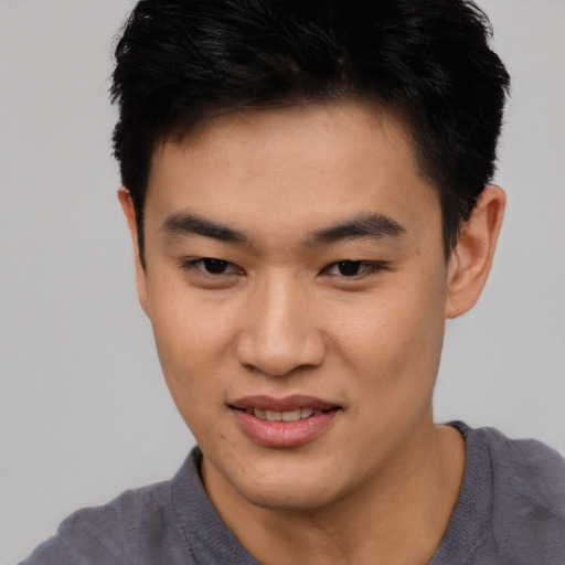 Joyful asian young-adult male with short  brown hair and brown eyes
