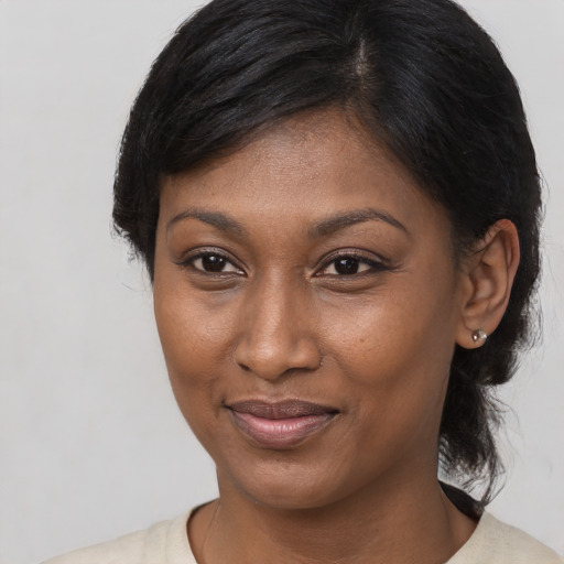 Joyful black young-adult female with medium  black hair and brown eyes
