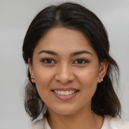 Joyful latino young-adult female with medium  brown hair and brown eyes