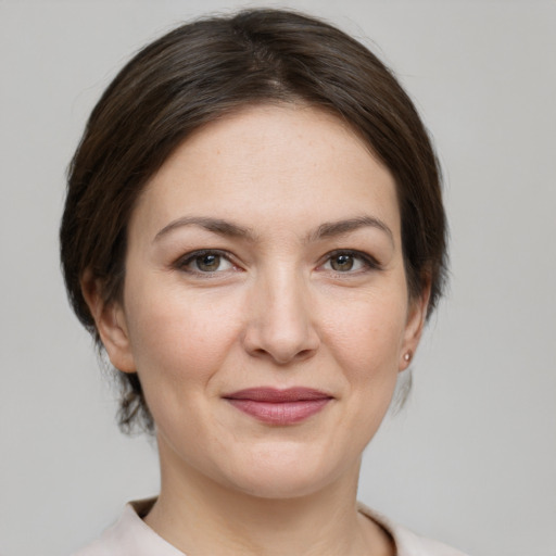 Joyful white young-adult female with medium  brown hair and grey eyes