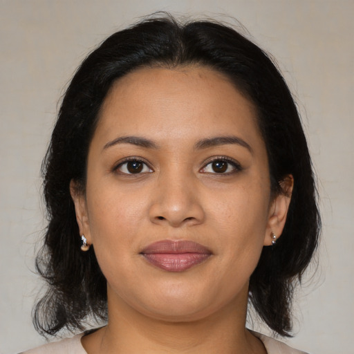 Joyful latino young-adult female with medium  brown hair and brown eyes