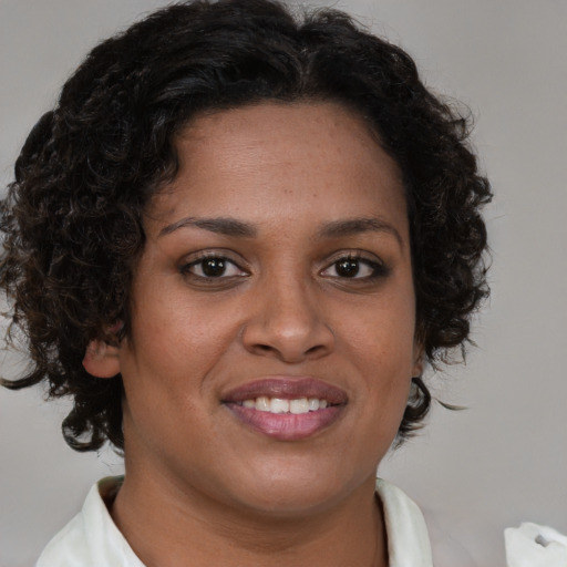 Joyful black young-adult female with short  brown hair and brown eyes