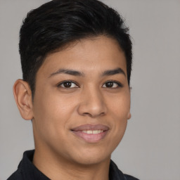 Joyful latino young-adult male with short  brown hair and brown eyes