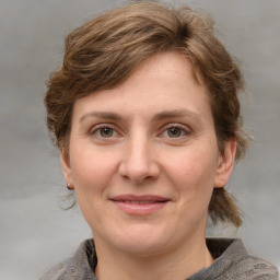 Joyful white young-adult female with medium  brown hair and grey eyes