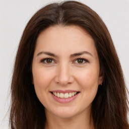 Joyful white young-adult female with long  brown hair and brown eyes