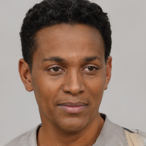 Joyful black young-adult male with short  black hair and brown eyes