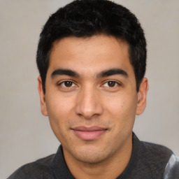 Joyful latino young-adult male with short  black hair and brown eyes