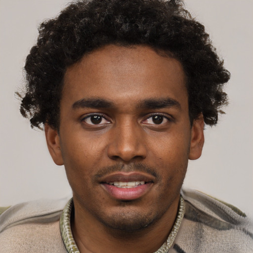 Joyful black young-adult male with short  brown hair and brown eyes