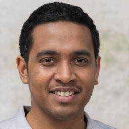 Joyful latino young-adult male with short  black hair and brown eyes