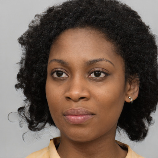 Joyful black young-adult female with medium  black hair and brown eyes