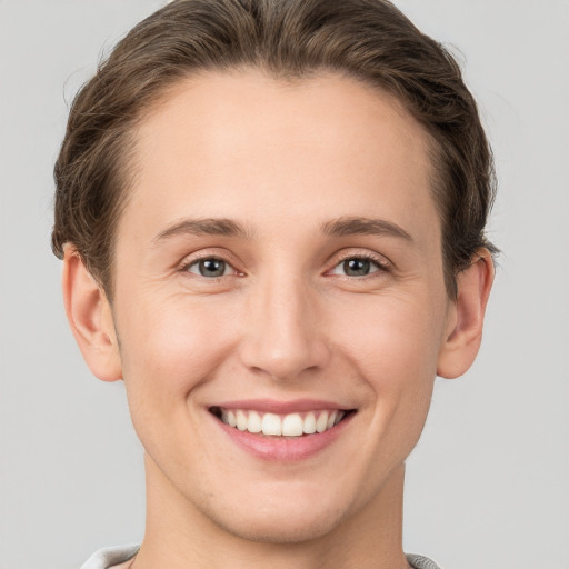 Joyful white young-adult female with short  brown hair and grey eyes