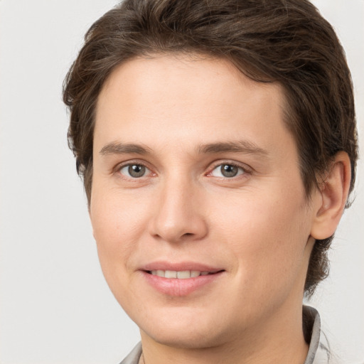 Joyful white young-adult female with short  brown hair and grey eyes