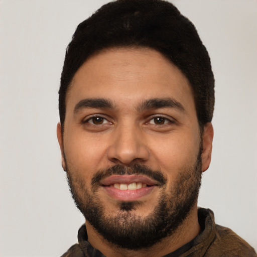 Joyful latino young-adult male with short  black hair and brown eyes