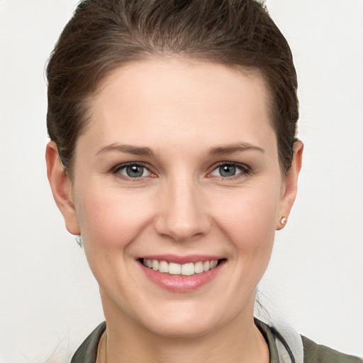 Joyful white young-adult female with short  brown hair and grey eyes