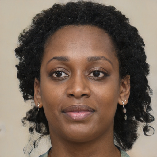 Joyful black young-adult female with long  brown hair and brown eyes