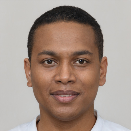 Joyful black young-adult male with short  brown hair and brown eyes