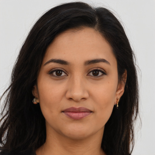 Joyful latino young-adult female with long  brown hair and brown eyes