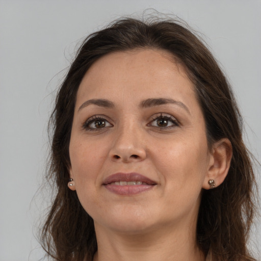 Joyful white young-adult female with long  brown hair and brown eyes