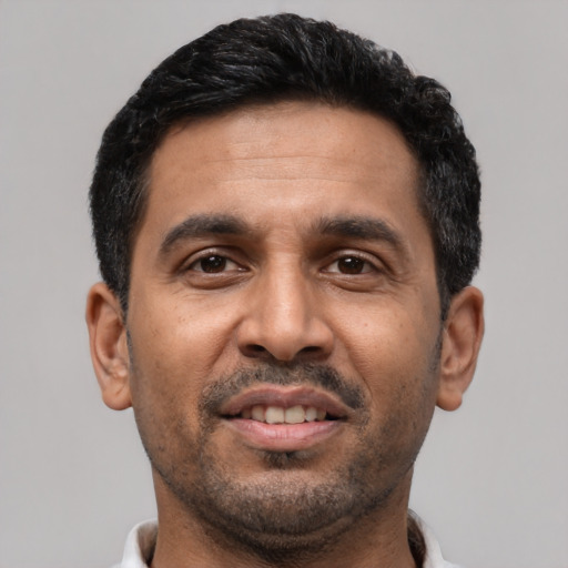 Joyful latino adult male with short  black hair and brown eyes