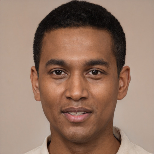 Joyful black young-adult male with short  black hair and brown eyes