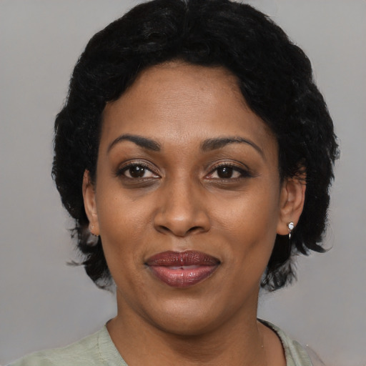 Joyful black adult female with short  black hair and brown eyes
