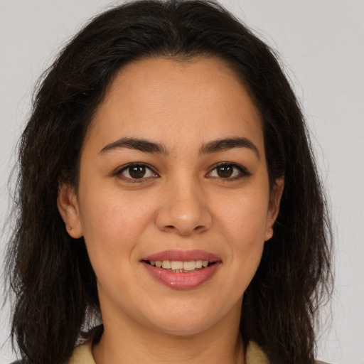 Joyful latino young-adult female with long  brown hair and brown eyes
