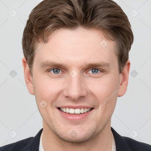 Joyful white young-adult male with short  brown hair and grey eyes