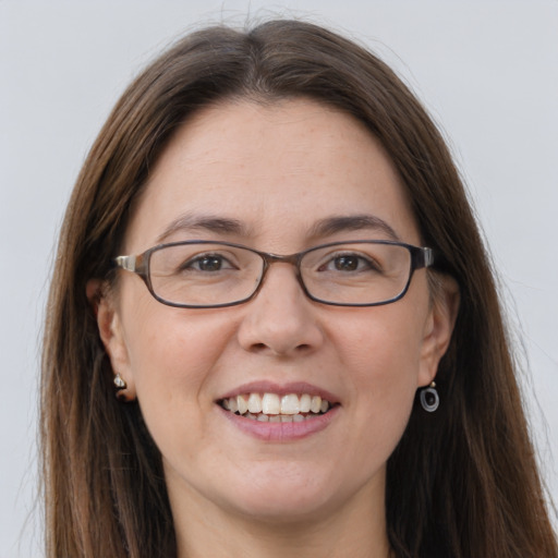 Joyful white adult female with long  brown hair and grey eyes