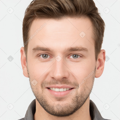 Joyful white young-adult male with short  brown hair and grey eyes