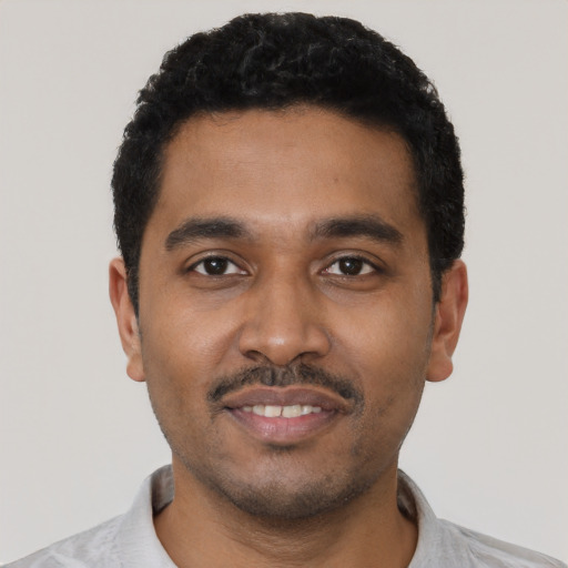 Joyful black young-adult male with short  black hair and brown eyes