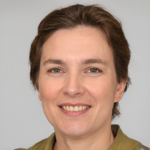 Joyful white adult female with medium  brown hair and green eyes