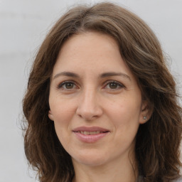 Joyful white adult female with long  brown hair and brown eyes