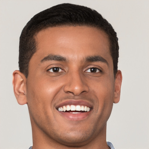 Joyful latino young-adult male with short  brown hair and brown eyes