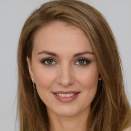 Joyful white young-adult female with long  brown hair and green eyes