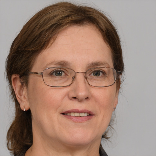 Joyful white adult female with medium  brown hair and blue eyes