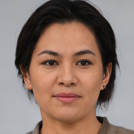 Joyful asian adult female with medium  brown hair and brown eyes