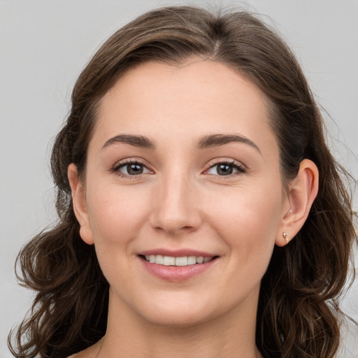 Joyful white young-adult female with long  brown hair and grey eyes