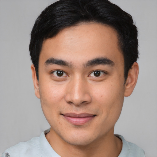 Joyful asian young-adult male with short  black hair and brown eyes