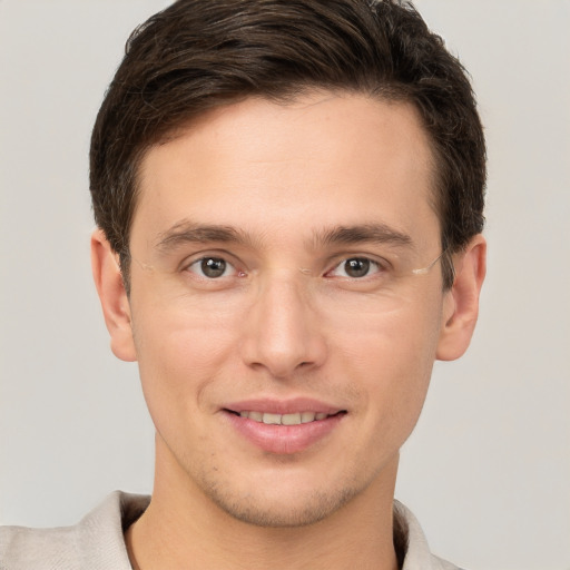 Joyful white young-adult male with short  brown hair and grey eyes