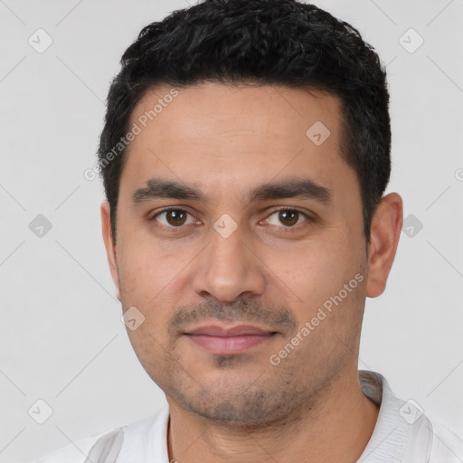 Joyful latino young-adult male with short  black hair and brown eyes