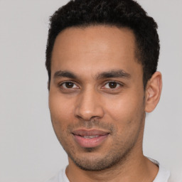 Joyful latino young-adult male with short  brown hair and brown eyes