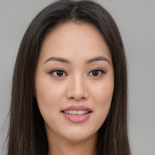 Joyful asian young-adult female with long  brown hair and brown eyes