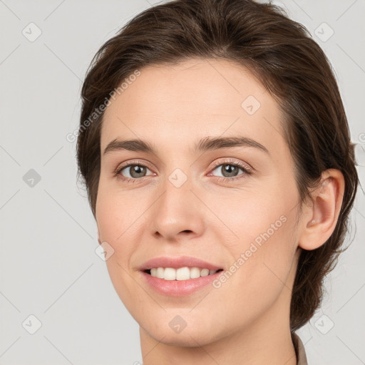 Joyful white young-adult female with medium  brown hair and grey eyes