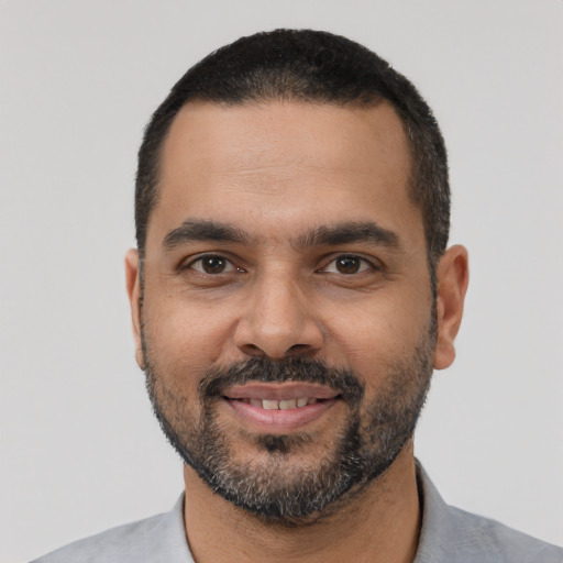 Joyful latino young-adult male with short  black hair and brown eyes