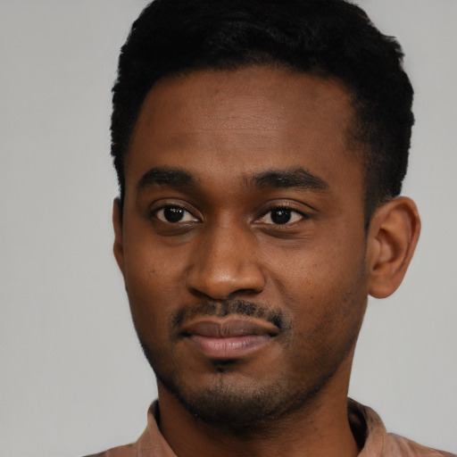 Joyful black young-adult male with short  black hair and brown eyes