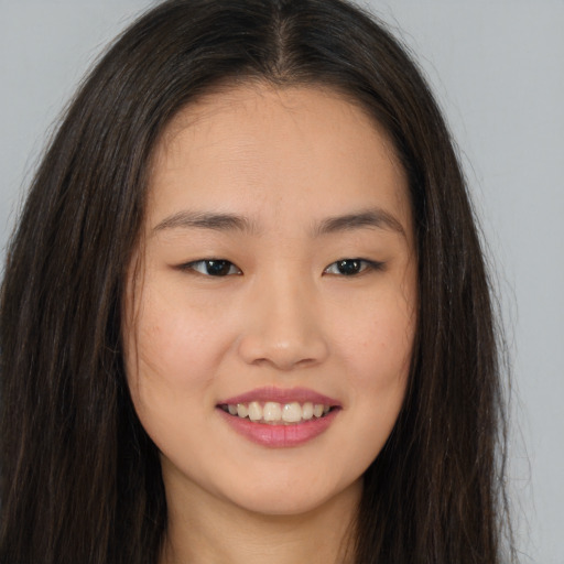 Joyful asian young-adult female with long  brown hair and brown eyes