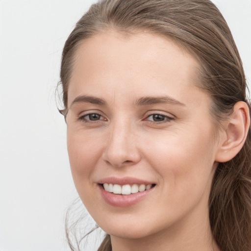 Joyful white young-adult female with long  brown hair and grey eyes