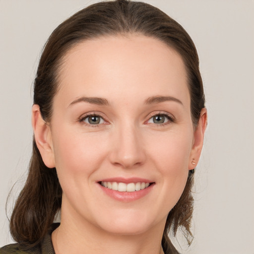 Joyful white young-adult female with medium  brown hair and grey eyes