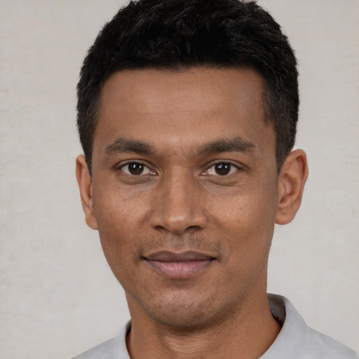 Joyful latino young-adult male with short  black hair and brown eyes